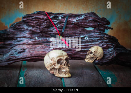 The skull and the clock on the old wooden floor. Stock Photo