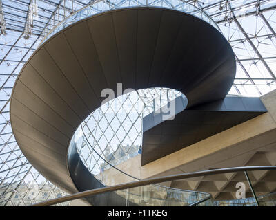 Louvre's Modern curving staircase under the Pyramid. This spiral staircase is part of the main pyramid entrance to the museum Stock Photo