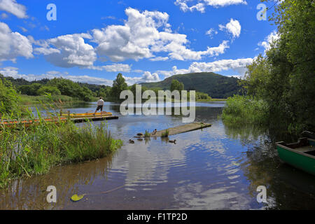 Man standing on a boat landing, Grasmere Lake, Cumbria Lake District National Park, England, UK. Stock Photo