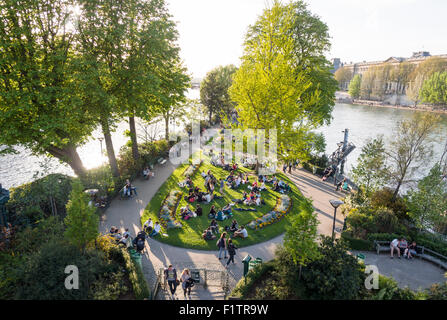 Park at the tip in the Seine . Tourists and locals enjoy the evening sunshine at the tip of the Île de la Cité Stock Photo