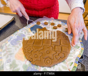 Lifting out the Big Star. A woman lifts out the large star in a circle of gingerbread to constructs a gingerbread Christmas tree Stock Photo