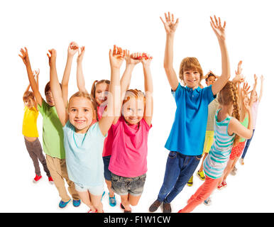 School age kids stand together with raised hands Stock Photo