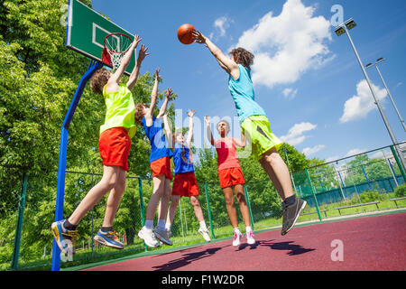 Children jump for ball during basketball game Stock Photo