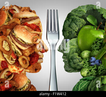 Nutrition decision concept and diet choices dilemma between healthy good fresh fruit and vegetables or greasy cholesterol rich fast food shaped as a human head divided by a fork as a symbol for trying to decide what to eat. Stock Photo