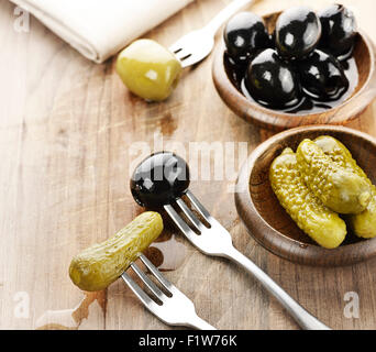 Pickles,Green And Black Olives On A Wooden Board Stock Photo