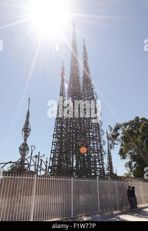 Silhouette of young men viewing the Watts Towers from behind a fence in Watts, California Stock Photo