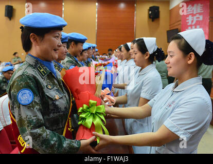 (150908) -- SHIJIAZHUANG, Sept. 8, 2015 (Xinhua) -- Medical staff members of Bethune International Peace Hospital offer flowers to colleagues who will leave for a 12-month United Nations peacekeeping mission in Liberia, in Shijiazhuang, capital of north China's Hebei Province, Sept. 7, 2015. These medical staff members are the first team of the 18th batch of Chinese peacekeepers sent on tour since 2003, when China joined the peacekeeping mission in Liberia under the UN Security Council's Resolution 1509. The second team is scheduled to set off on Sept. 17. The 18th batch has 508 soldiers in to Stock Photo