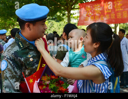 (150908) -- SHIJIAZHUANG, Sept. 8, 2015 (Xinhua) -- Wife of Luo Tao, a medical staff member who will leave for a 12-month United Nations peacekeeping mission in Liberia, adjust uniforms for his husband at Bethune International Peace Hospital in Shijiazhuang, capital of north China's Hebei Province, Sept. 7, 2015. These medical staff members are the first team of the 18th batch of Chinese peacekeepers sent on tour since 2003, when China joined the peacekeeping mission in Liberia under the UN Security Council's Resolution 1509. The second team is scheduled to set off on Sept. 17. The 18th batch Stock Photo