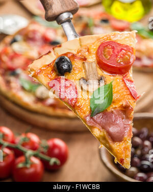 Piece of pizza with mushrooms, ham and tomatoes. Top view. Stock Photo