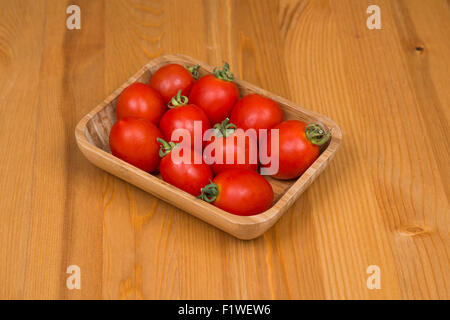 Cherry tomatoes, wooden background, in a pot Stock Photo