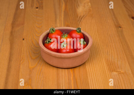 Cherry tomatoes, wooden background, in a pot Stock Photo