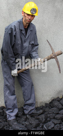 Miner using a pickaxe to break up the mining of coal Stock Photo