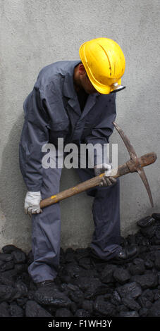 Miner using a pickaxe to break up the mining of coal Stock Photo