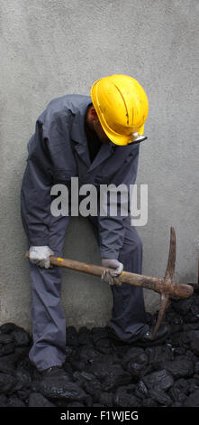 Miner using a pickaxe to break up the mining of coal Stock Photo