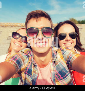 group of smiling friends taking selfie outdoors Stock Photo