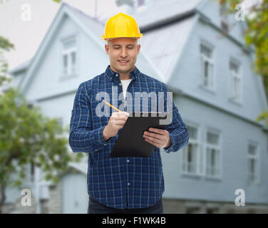 smiling male builder in helmet with clipboard Stock Photo