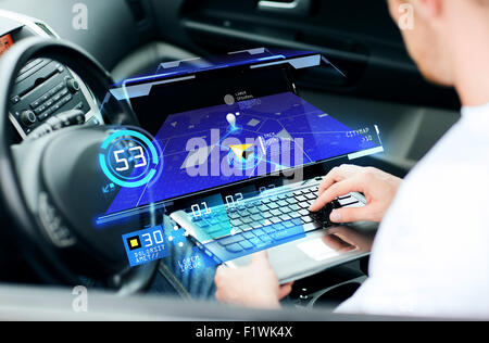 man using navigation on laptop computer in car Stock Photo
