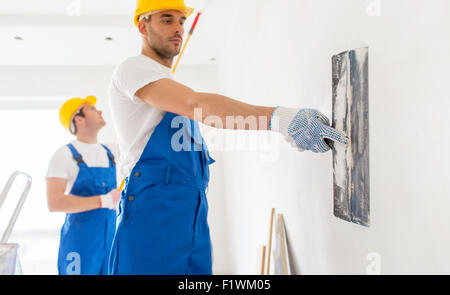 two builders with painting tools repairing room Stock Photo