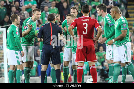 Windsor Park, Belfast, UK. 7th September, 2015. Northern Ireland players listen to referee Cüneyt Çakιr explaining why defender Chris Baird was being sent off. David Hunter/Alamy Live News. Stock Photo