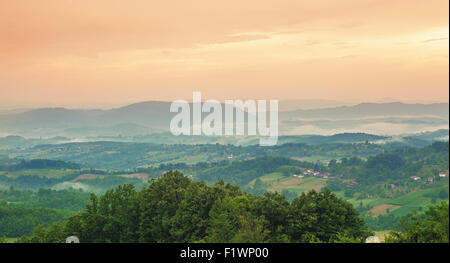 Orange sunset in late summer period, field, meadows and forests of a village in Serbia. Stock Photo