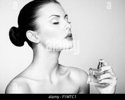Young beautiful woman with bottle of perfume. Perfect Makeup. Fashion photo Stock Photo