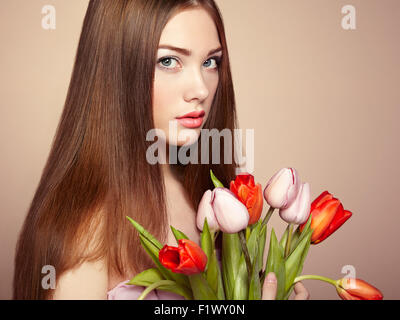 Portrait of beautiful dark-haired woman with flowers. Fashion photo Stock Photo