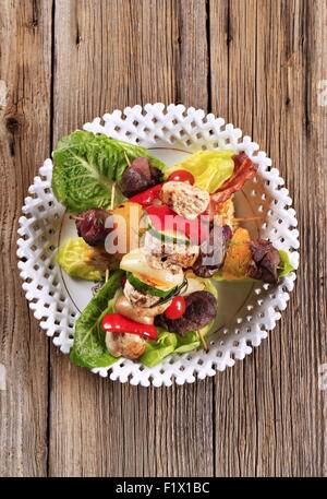 Grilled shish kebabs on lettuce leaves - overhead Stock Photo