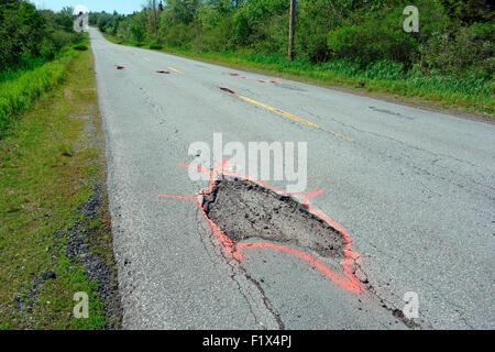 Potholes in a paved road or highway Stock Photo