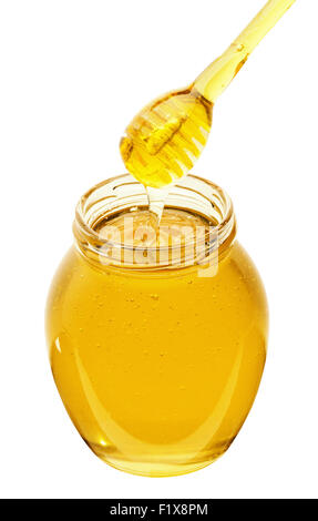 Honey dripping from a honey dipper into jar. Stock Photo