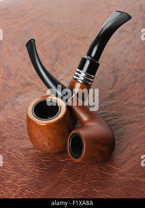Tobacco pipes on leather background. Stock Photo