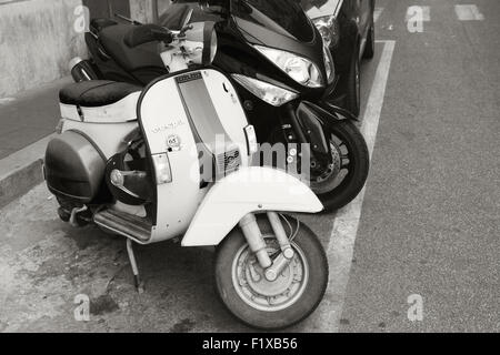 Rome, Italy - August 07, 2015:  Classic old style Vespa scooters stand parked on a roadside in the city Stock Photo
