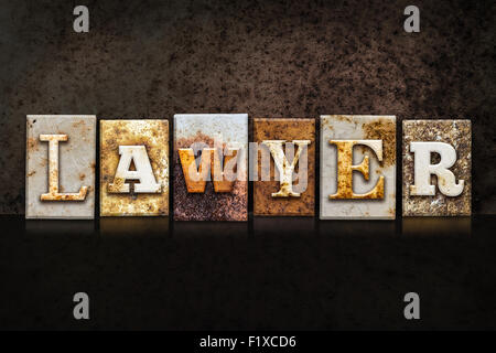 The word 'LAWYER' written in rusty metal letterpress type on a dark textured grunge background. Stock Photo