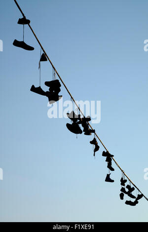 Pairs of shoes hanging from on a wire in Prague, Czech Republic Stock Photo