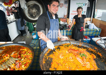 A chef cooks a large paella at a food stall at Cowes, Isle of Wight, during Cowes Week 2015 Stock Photo
