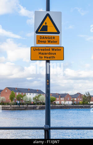 Danger deep water sign with another sign advising of untreated water hazardous to health near housing. Manchester, England, UK Stock Photo