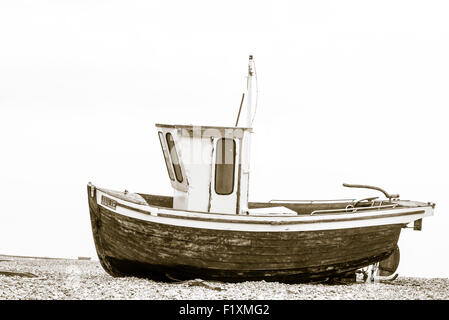 Split toned side view of a fishing boat beached at Deal in Kent with the North Sea in the background Stock Photo