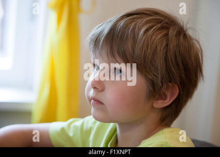 a little boy who looks and listens attentively Stock Photo