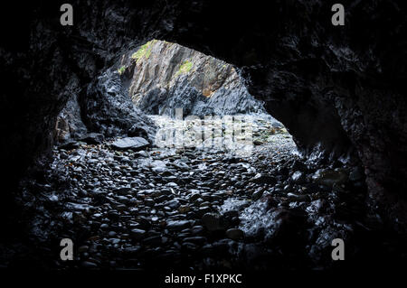 Dark cave on the beach at Trefin in Pembrokeshire, Wales. Stock Photo