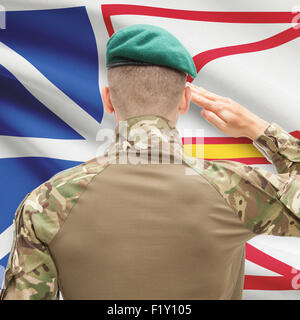 Soldier saluting to Canadial province flag series - Newfoundland and Labrador Stock Photo