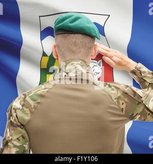 Soldier saluting to Canadial province flag series - Northwest Territories Stock Photo