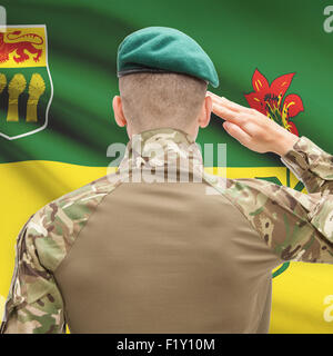 Soldier saluting to Canadial province flag series - Saskatchewan Stock Photo