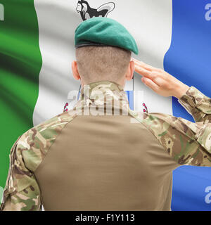 Soldier saluting to Canadial province flag series - Yukon Stock Photo