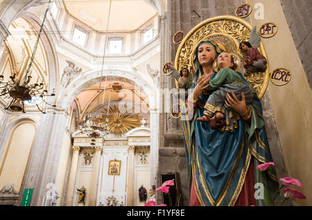 A statue of Mary and Child in front of the main altar of Iglesia de la Santisima Trinidad in Mexico City, Mexico. Iglesia de la Santisima Trinidad translates as Church of the Holy Trinity. Stock Photo