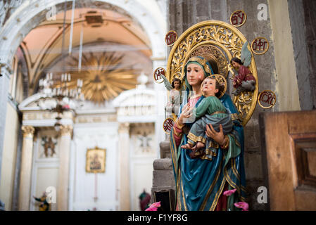 A statue of Mary and Child in front of the main altar of Iglesia de la Santisima Trinidad in Mexico City, Mexico. Iglesia de la Santisima Trinidad translates as Church of the Holy Trinity. Stock Photo