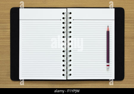 blank spiral notebook and pencil on wood background Stock Photo