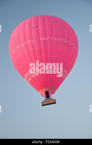 Pink air balloon with advertising logo by Ballongflyg Upp & Ner take off in the evening sky over Stockholm, Sweden.