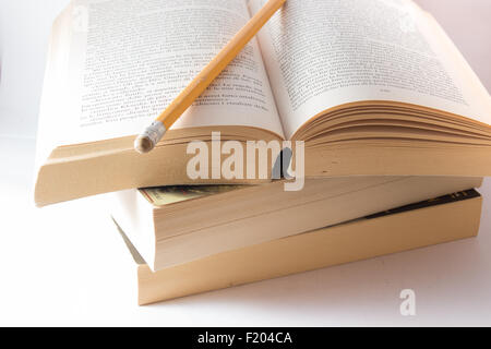 Stack of old books and pencil on wooden table. Stock Photo