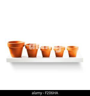Clay flower pots in a row on shelf isolated on white background. Garden equipment. Group of objects with clipping path Stock Photo