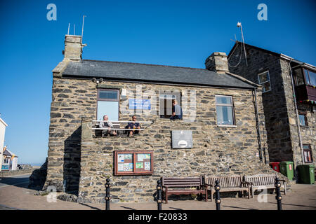 Men sitting outside the Harbour Masters Office at barmouth gwynedd Wales UK Stock Photo