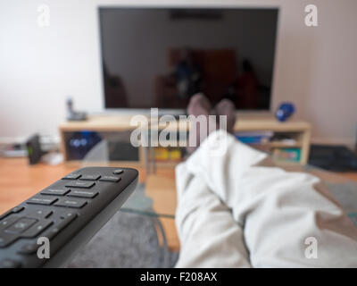 Beine auf dem Tisch vorm Fernseher Stock Photo